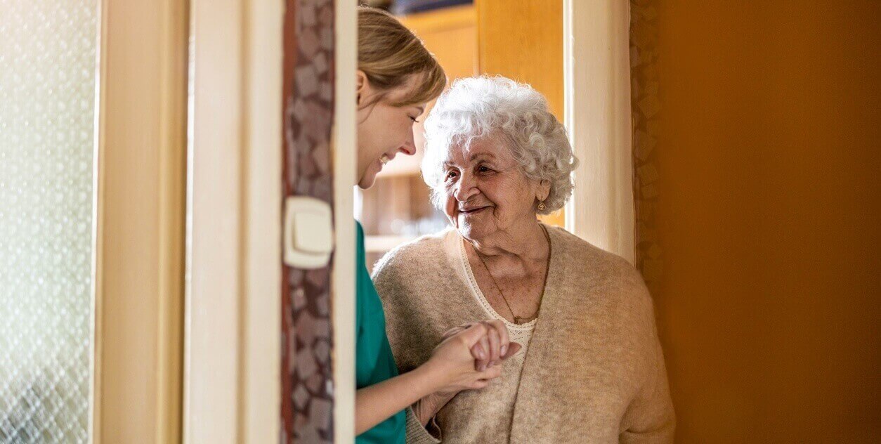 zorgverleners houden oudere vrouw met dementie gezelschap