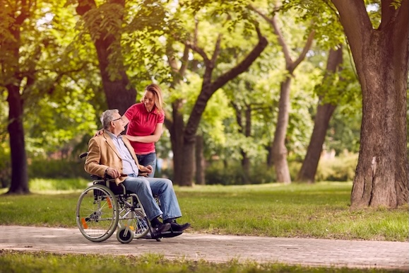 senior man in wheelchair in the park with daughter 24 uurs zorg bij ALS